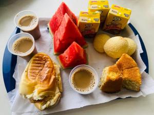 a plate of food with cups of coffee and fruit at Hotel Cetro in Belo Horizonte