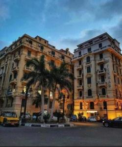 two large buildings with palm trees in front of them at Graeco-Roman Residence-Delilah in Alexandria