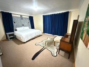 a hotel room with a bed and a zebraebraebraebra at Vimbainashe Villas in Umtali