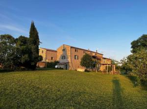 a large yard with a large brick building at Le Mas Vivarés in Lablachère