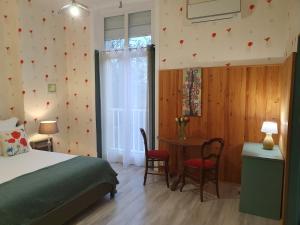 a bedroom with a bed and a table with chairs at Villa Honorine in Saint-Honoré-les-Bains