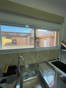 a kitchen with a sink and a window with a view at Fully equipped studio apartments in Apóstoles
