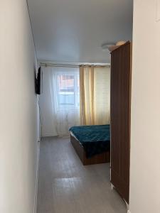 a small bedroom with a bed and a window at Garsoniera mobilata si utilata in Chiajna