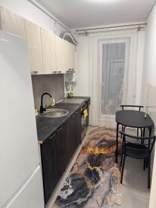 a kitchen with a sink and a table at Garsoniera mobilata si utilata in Chiajna +4 photos