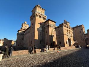 a group of people walking in front of a castle at Al Castello in Ferrara