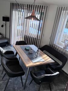 a dining room with a wooden table and black chairs at Ferienwohnung Gritsch Sommercard inclusive in Jerzens +23 photos