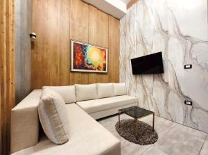 a living room with a couch and a tv at Colombia Apartments&Rooms in Durrës