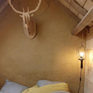 a bedroom with a antlers on the wall and a lamp at Le Temps du Coeur - TYNID in Saint-Ganton