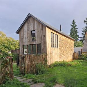 a wooden house with a fence in a yard at Le Temps du Coeur - TYNID in Saint-Ganton