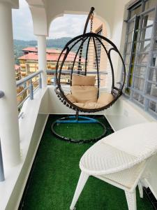 a swing on a balcony with a green floor at Bethany Cushy Home Ltd in Kisii