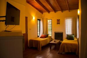 a room with two beds and a flat screen tv at Cabañas La Morera in Villa Ventana +59 photos