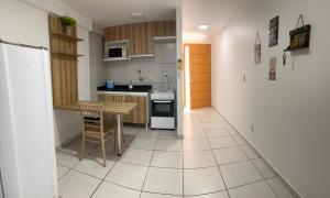 a small kitchen with a table and a refrigerator at Studio Easy West Flat in Mossoró