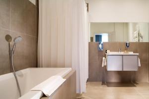 a bathroom with a bath tub and a sink at Villa Diana in Molsheim