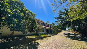 a house with a pathway next to a building at The Eco Palace Hostel in Búzios