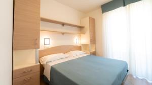 a bedroom with a blue bed and a window at Appartamenti per Vacanze Anchisemare in Alba Adriatica +59 photos