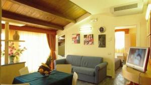 a living room with a couch and a tv at Appartamenti per Vacanze Anchisemare in Alba Adriatica