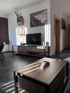 a living room with a coffee table and a flat screen tv at Ferienwohnung Gritsch Sommercard inclusive in Jerzens