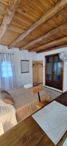 a bedroom with a large bed and a wooden ceiling at Cabañas Cerro Colonial in Trapiche +25 photos