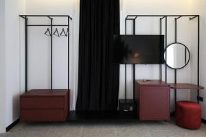a room with a tv and a desk with a mirror at Hotel Bazaar Center in Tirana