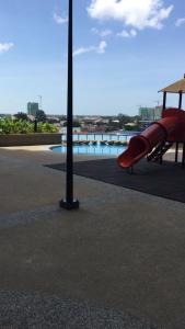 a red slide in a playground with a pool at Staycity Apartment - D'Perdana Sri Cemerlang in Kota Bharu