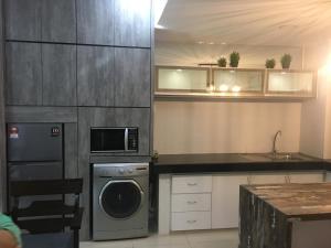 a kitchen with a washing machine and a microwave at Staycity Apartment - D'Perdana Sri Cemerlang in Kota Bharu