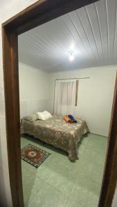 a bedroom with a bed in the corner of a room at Casinha no Sítio in Guaramiranga