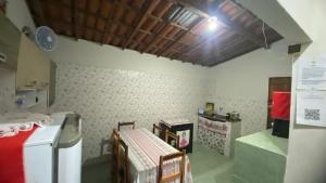 a kitchen with a refrigerator and a table and chairs at Casinha no Sítio in Guaramiranga