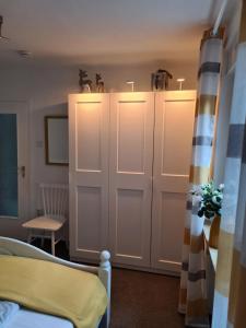 a bedroom with white wardrobes with lights on them at Cozy basement apartment in Mettmann in Mettmann