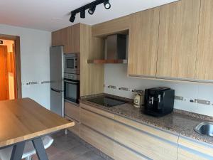 a kitchen with wooden cabinets and a counter top at Pilgrim’s House in O Pedrouzo
