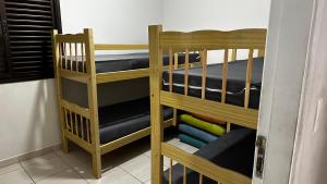 two bunk beds in a room with blue mattresses at Apartamento Satel Praia in Itanhaém