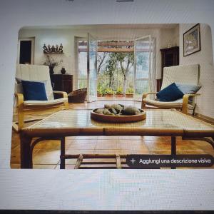 a living room with a table and two chairs at Villa vista mare in Procchio