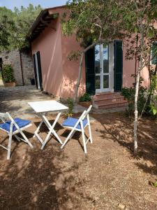 two chairs and a table in front of a house at Villa vista mare in Procchio