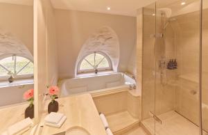 a bathroom with a bath tub and a shower at Söl'ring Hof in Rantum +54 photos
