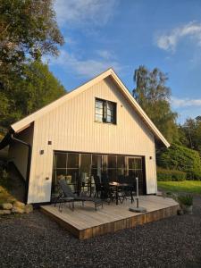 a barn with a table and chairs on a deck at The little house by the paddock - only for non smokers in Gothenburg +15 photos