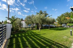 a yard with trees and a fence at Oasis Houses Maggana ,Xanthi in Mángana
