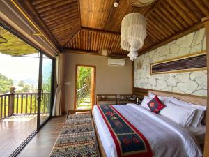 a bedroom with a bed and a balcony at Chapa Ecolodge in Sapa