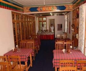 a room with tables and chairs and a man standing in a room at Hotel Galaxy Ladakh in Leh