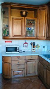 a kitchen with wooden cabinets and a microwave at Casa Vallina - Garden & Mountain View in Castion