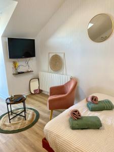 a room with two beds and a chair and a mirror at Studio Cozy in Gençay
