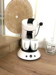a coffee maker sitting on a counter with two cups at Studio Cozy in Gençay