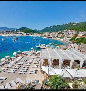 a beach with chairs and umbrellas and the water at Apartments Nikitenko Meljine in Meljine