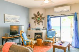 a living room with a couch and a tv and a fireplace at Paradise Villas #16 in Playa Encanto