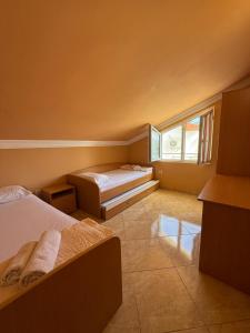 a bedroom with two beds and a window at Apartments Nikitenko Meljine in Meljine