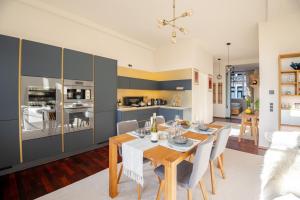 a kitchen and dining room with a table and chairs at EDLER WOHNRAUM Design-Loft im Graphischen Viertel 2 Schlafzimmer mit Balkon, Miele-Kaffeevollautomat, Miele-Weinkühler, Klima, Lift, Tiefgarage & WLAN 266 Mbps in Leipzig +37 photos