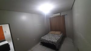 a small bedroom with a bed and a light on the ceiling at Apt 402 Ed Nilson Pimentel in Barreiras +2 photos