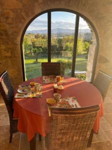 a table with a red table cloth on it with a window at Le Mas Vivarés in Lablachère