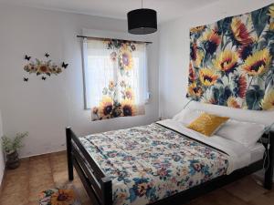 a bedroom with a bed with a floral headboard and a window at Traditional Peniche House in Peniche
