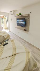 a bedroom with a bed with a tv on the wall at Suite de Lujo Castañitas in Tafí del Valle
