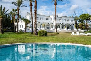 an empty pool in front of a mansion at Palacio Suites Marbella in Marbella