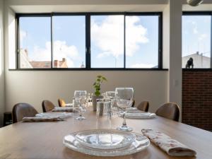 a table with glasses and plates on it with windows at Climatisé et atypique, bienvenue au LOFT-23 in Cholet
